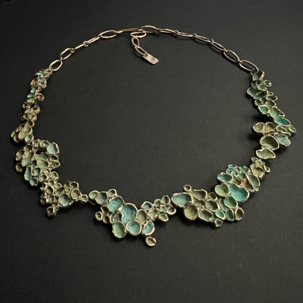 Collier artisanal en bronze patiné vert de la collection Sculpture Sauvage par l'Atelier Herbarium.