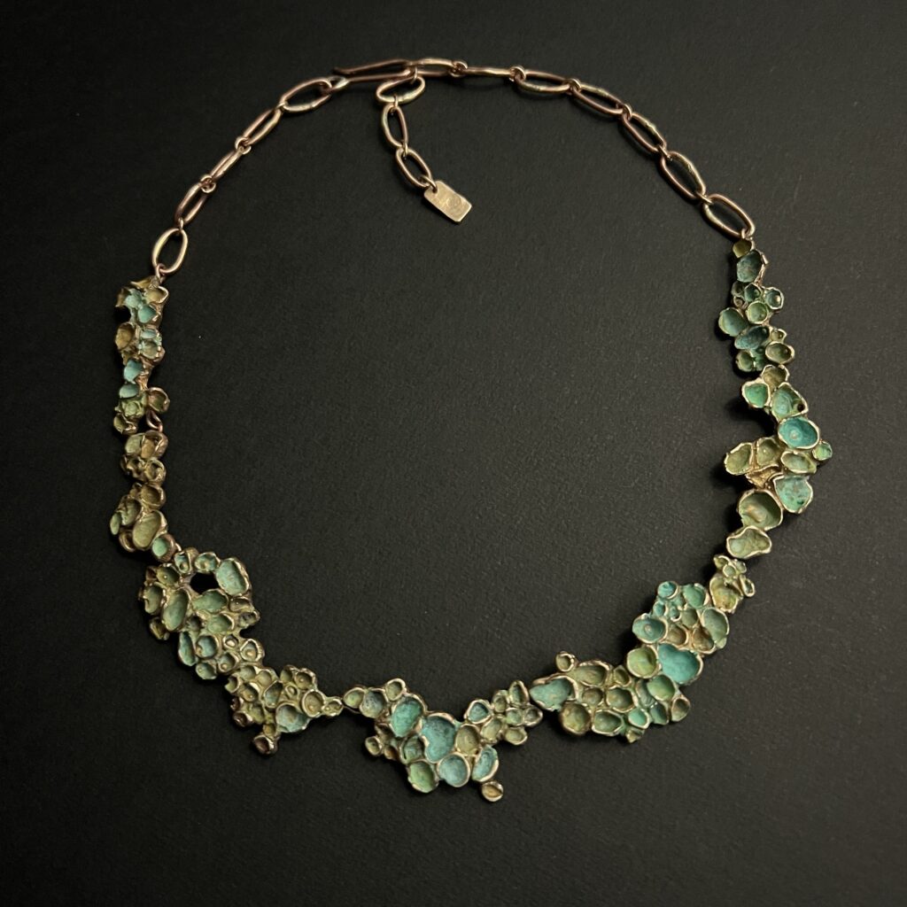 Collier artisanal en bronze patiné vert de la collection Sculpture Sauvage par l'Atelier Herbarium.